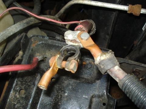 1994 Ford F-350 - Close-up of corroded battery terminals and wiring, showing copper cables and a red wire.