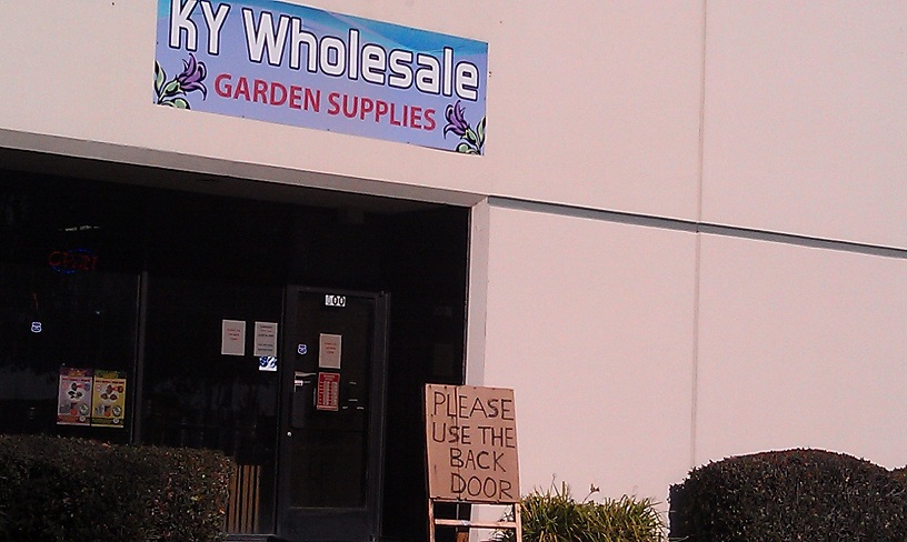 Storefront with KY Wholesale Garden Supplies sign and a 'Please Use Back Door' sign