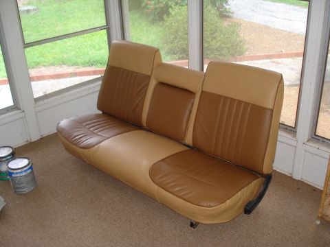1967 Ford F-250 - Bench seat with two-tone upholstery and a center armrest is shown indoors.