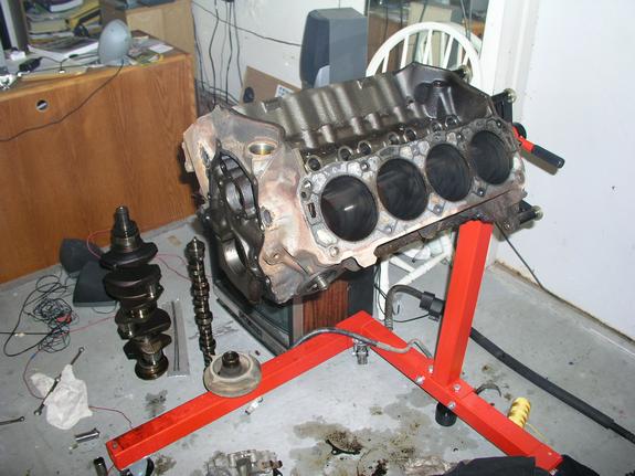 Engine block on stand with crankshaft and camshaft nearby