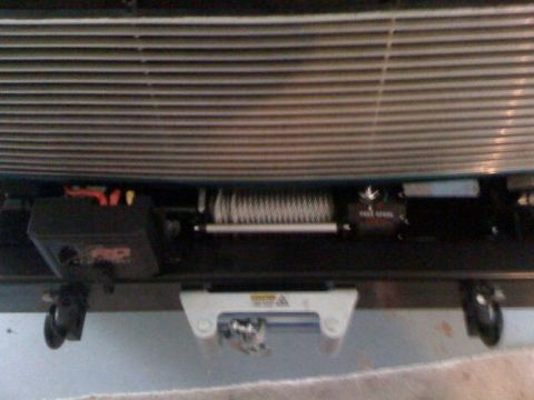1996 Ford Bronco - Close-up of a winch and tow hook mounted on a vehicle's front bumper.