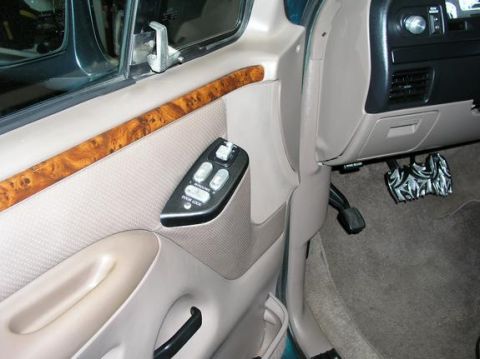 1996 Ford Bronco - Interior view of a 1996 Ford Bronco, showing the door panel, wood trim, and dashboard controls.