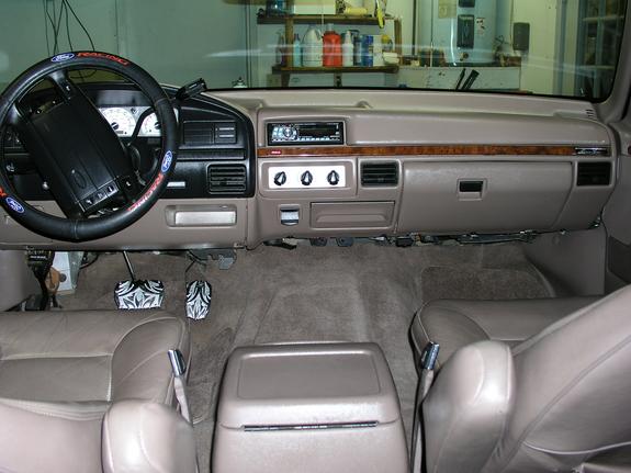 Tan interior of a 1992 Ford F-150 pickup truck, showing the dashboard, steering wheel, and seats
