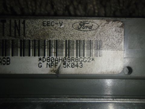 1996 Ford Bronco - Close-up of a Ford EEC-V engine control unit, showing its label with a barcode and part number.