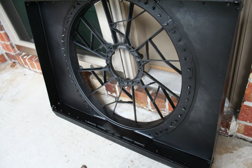black plastic radiator fan shroud with a circular fan hub and spokes