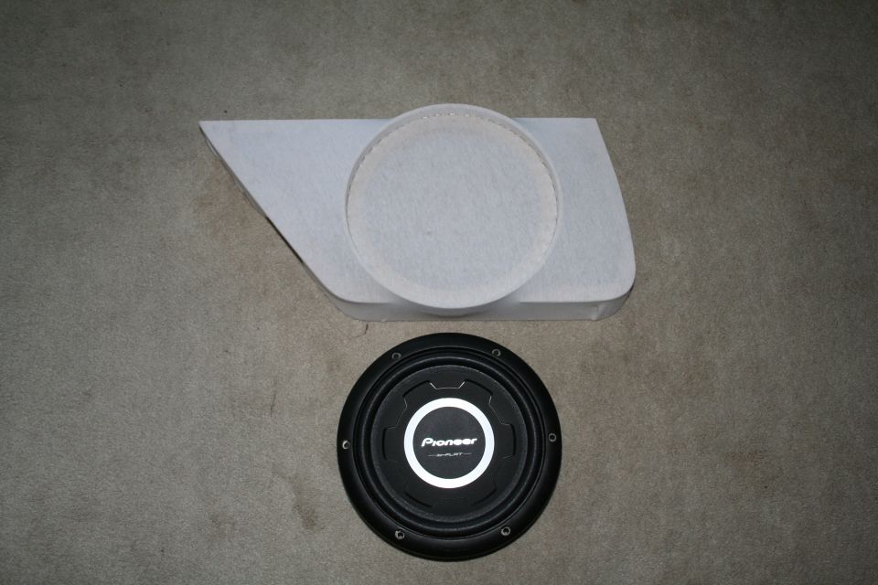 Car door panel with a circular cutout and a Pioneer subwoofer