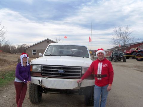 1989 Ford Bronco - People in Santa hats pose with a 1989 Ford Bronco during a holiday event.