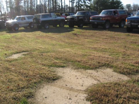 1994 Ford Bronco - Several SUVs, including a 1994 Ford Bronco, are parked in a grassy area.
