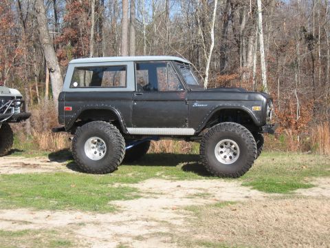 1994 Ford Bronco - This lifted Bronco features a two-tone paint scheme and prominent "Bronco" badging on the fender.