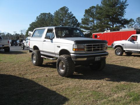 1994 Ford Bronco - This lifted 1994 Ford Bronco is parked outdoors with another vehicle visible in the background.