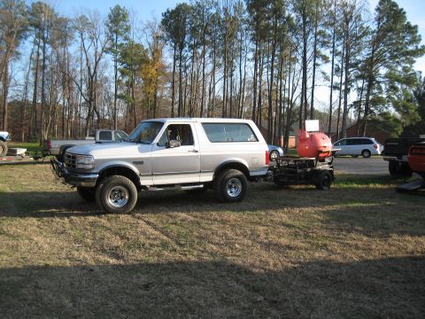 1994 Ford Bronco - 1994 Ford Bronco is seen towing a trailer with a grill attached.