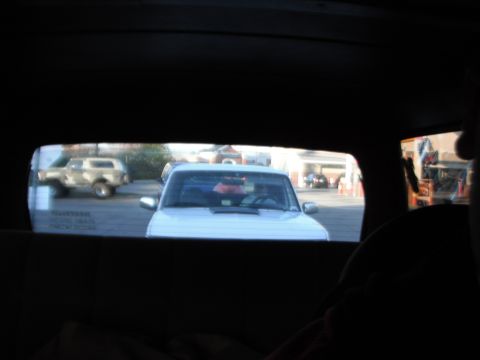 1989 Ford Bronco - A white pickup truck is viewed from behind, with another SUV visible in the distance.