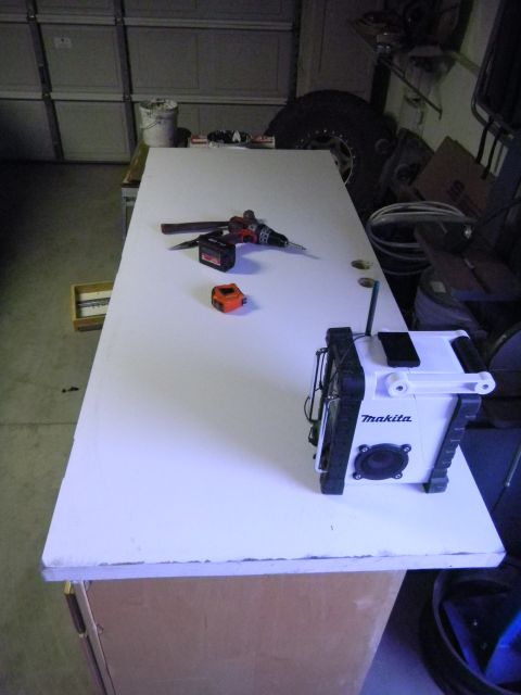 1997 Ford Ranger - Tools and a radio sit on a white door placed on a workbench in a garage.
