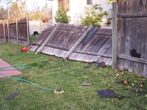 1990 Ford Bronco - A backyard scene shows a damaged wooden fence with debris scattered on the lawn.