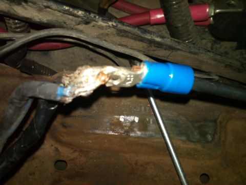 1988 Ford Bronco - Close-up of a corroded battery terminal with a blue connector and associated wiring.