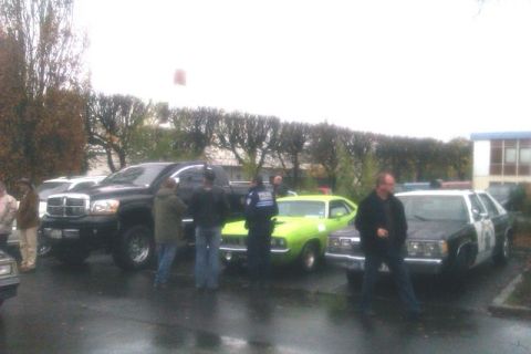 1991 Ford LTD Crown Victoria - A 1991 Ford Crown Victoria police car is parked alongside other vehicles, including a black pickup truck and a lime green muscle car.