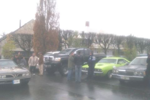 1991 Ford LTD Crown Victoria - A gathering of vehicles and individuals on a cloudy day, with a prominent black pickup truck.
