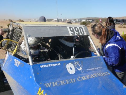 1988 Ford Bronco - A blue off-road buggy with the number 990 on its roof is seen with drivers and onlookers.