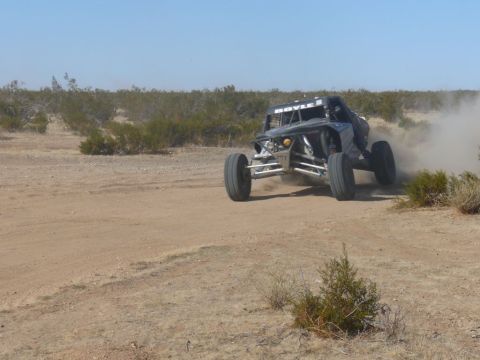 1988 Ford Bronco - This off-road buggy is racing through a dusty desert landscape.