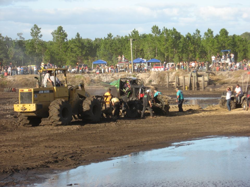 Mud bogging scene with John Deere tractor and off-road vehicles