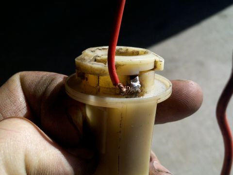 1978 Ford Bronco - A close-up shows a damaged bulb socket with a red wire attached, indicating a repair.