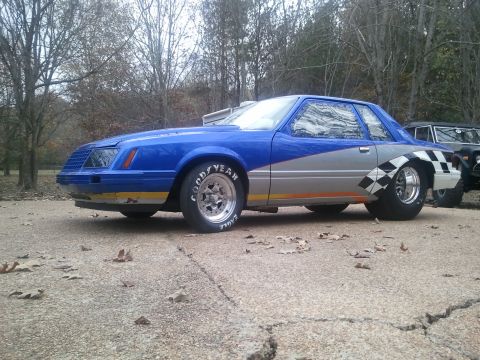 1967 Ford Mustang - This modified Ford Mustang drag car features a distinctive blue and silver paint scheme with checkerboard accents.