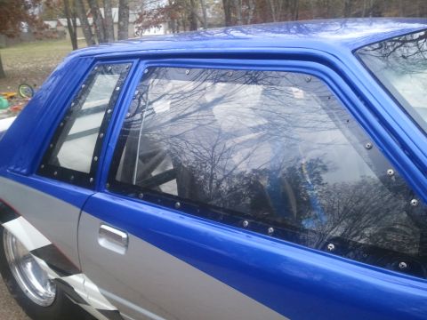 1967 Ford Mustang - A blue and silver drag car is shown from the side, bolted windows and an interior roll cage.