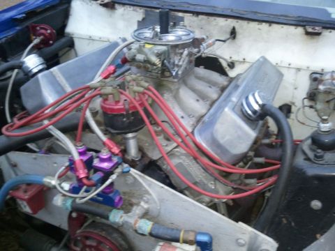 1967 Ford Mustang - Close-up of a V8 engine with performance modifications, including a Holley carburetor and braided fuel lines.