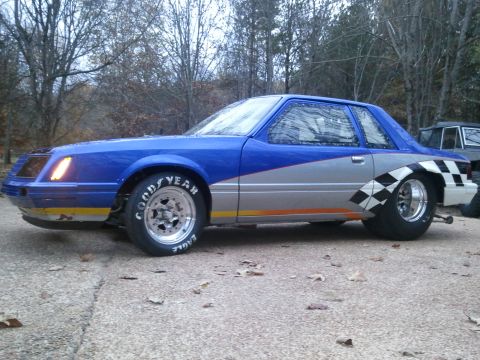 1967 Ford Mustang - A modified drag car with a distinctive blue and silver paint scheme sits parked outdoors.