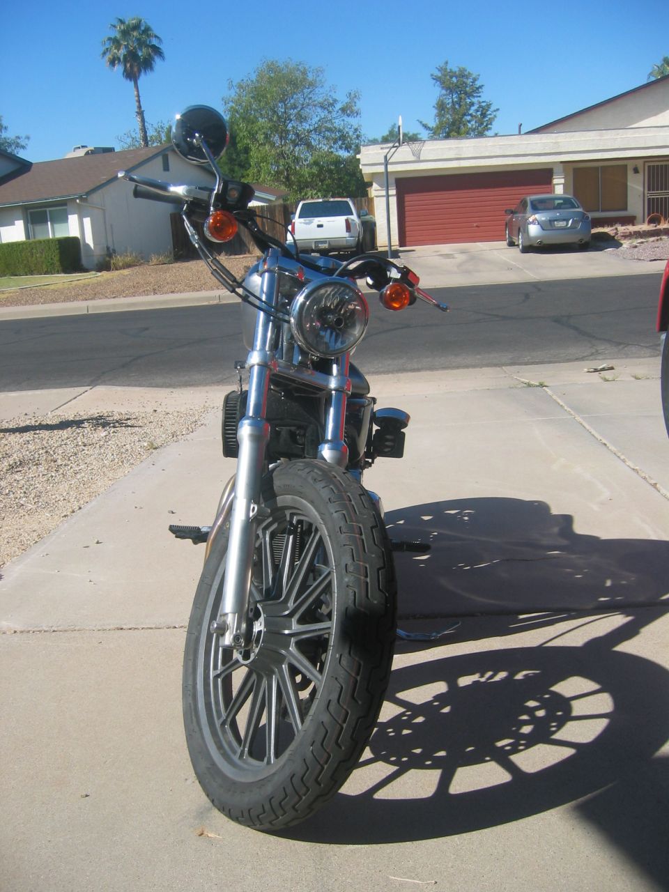 2006 Harley-Davidson Sportster motorcycle, front view, chrome details, black wheel, parked on driveway