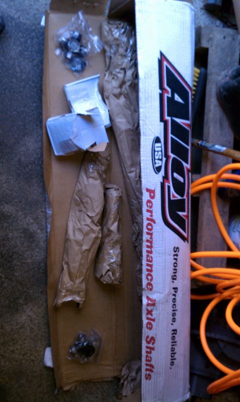 1979 Ford Bronco - A box containing performance axle shafts and associated hardware is shown, along with an orange extension cord.