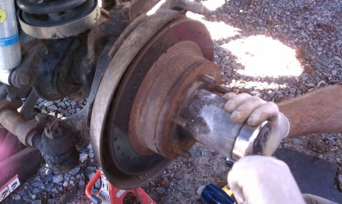 1979 Ford Bronco - Working on a vehicle's brake rotor and hub assembly, showing rusty components.