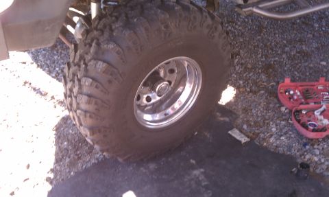 1979 Ford Bronco - A close-up view of a vehicle's off-road tire and wheel, with a toolbox open nearby.
