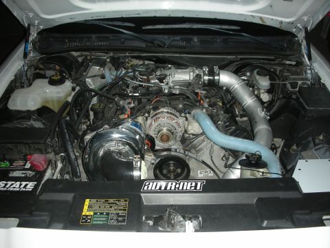 2004 Ford Crown Victoria - Engine bay view shows a modified engine with a prominent supercharger and custom piping.