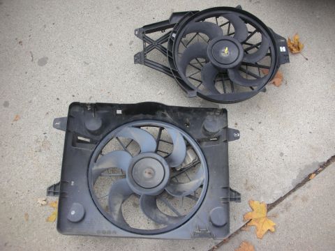 2004 Ford Crown Victoria - Two radiator fans are shown on a concrete surface, with fallen leaves nearby.