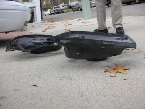 2004 Ford Crown Victoria - Car parts, a fan and shroud, are on the ground near a white vehicle.