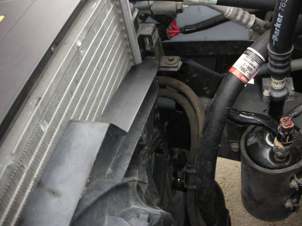 Radiator and fan assembly with hoses and electrical connectors. A label on a hose reads '3-9828-C'