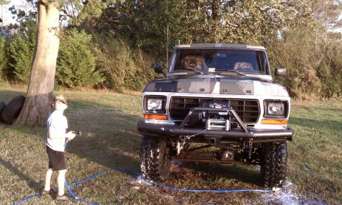 1979 Ford Bronco - A 1979 Ford Bronco with camouflage paint and a winch is parked outside on a sunny day.