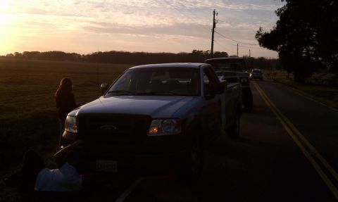 1979 Ford Bronco - Two trucks and a car on a rural road during sunset.