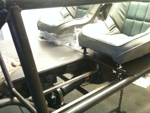1966 Ford Bronco - Interior view of a buggy, showing two grey bucket seats and part of the roll cage structure.