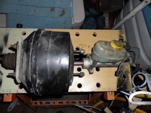 1994 Jeep Cherokee - A brake booster and master cylinder assembly is shown mounted on a wooden board, likely for repair or inspection.
