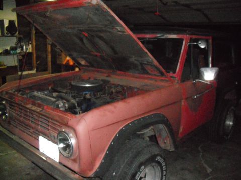 1991 Ford Bronco - This classic Ford Bronco is parked in a garage with its hood raised, revealing the engine compartment.
