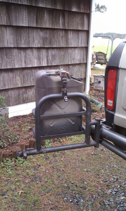 1979 Ford Bronco - A Jerry can is attached to the rear of a vehicle, secured by a metal rack and lock.
