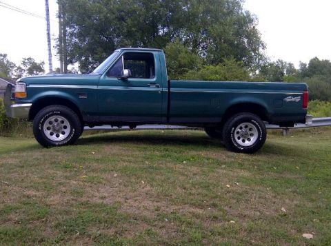 1996 Ford F-150 - Side view of a green 1996 Ford F-150 pickup truck.