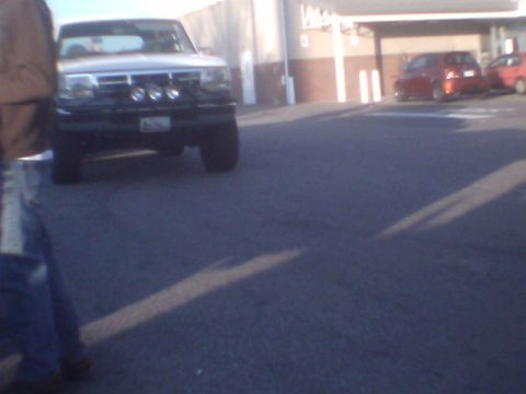 1979 Ford Bronco - A white pickup truck with multiple auxiliary lights mounted on its front grille is parked in an outdoor lot.
