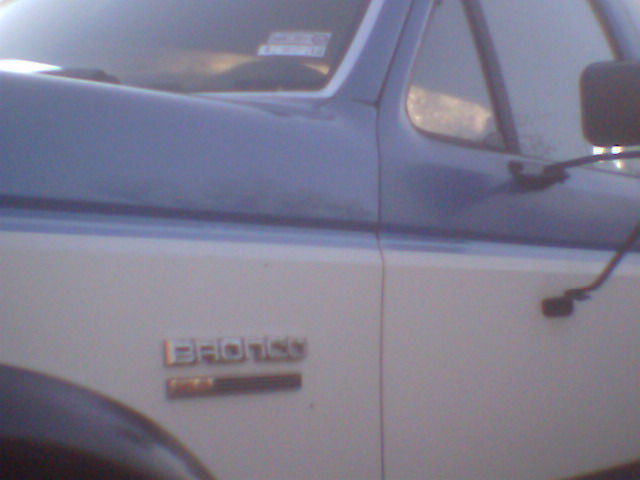1979 Ford Bronco emblem on side of two-tone vehicle. Supermotors.net logo visible