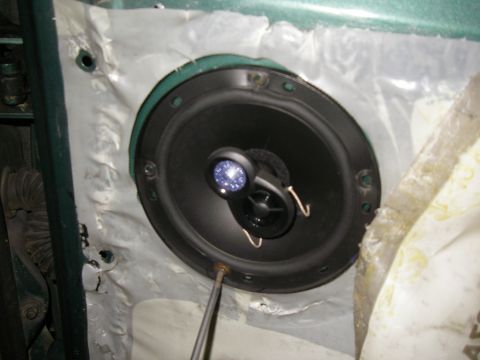1990 Ford Bronco - A close-up view of a car's interior door panel with a speaker installed.