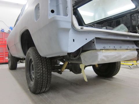 1987 Dodge 1500 - The rear section of a truck is visible, undergoing bodywork with primer applied.
