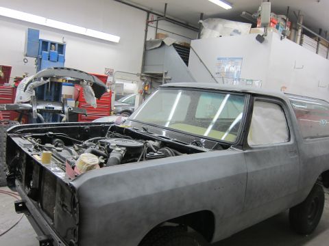 1987 Dodge 1500 - A Dodge Ramcharger is in a body shop, undergoing repairs with its hood open and primer applied.
