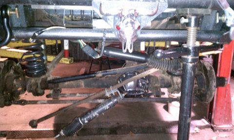 1979 Ford Bronco - Undercarriage view shows the steering and suspension system of a vehicle, possibly undergoing maintenance.